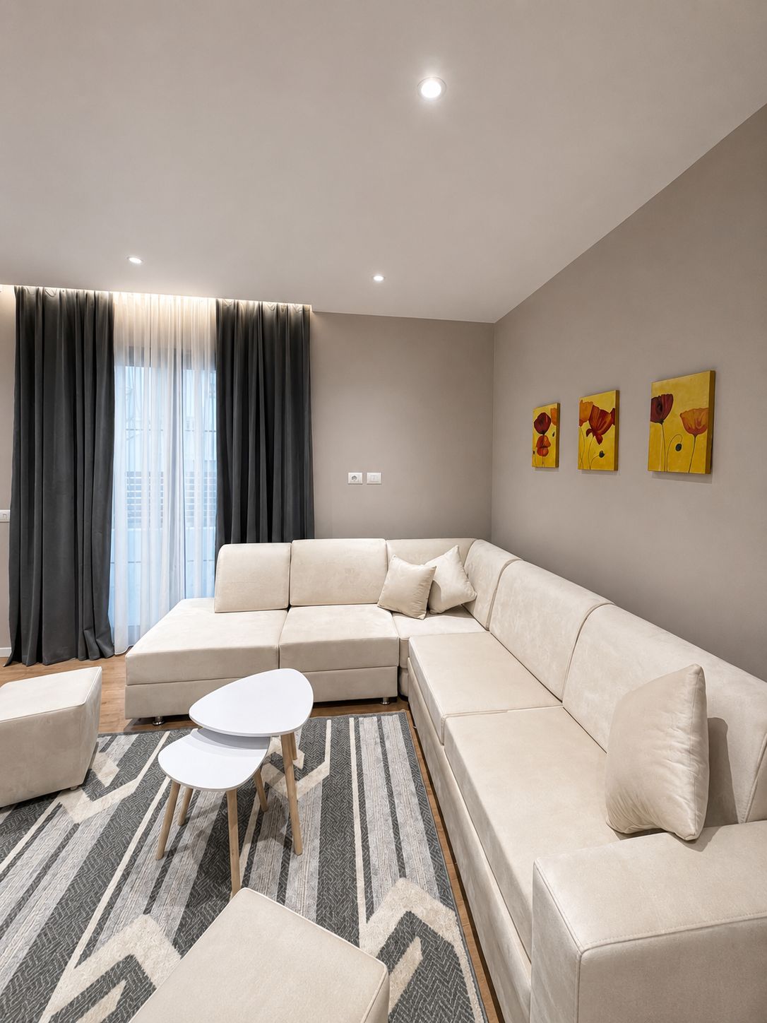 A modern living room with a sectional sofa, a round coffee table, and a patterned rug.