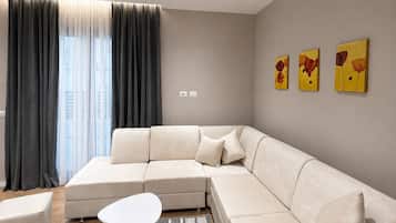A modern living room with a sectional sofa, a round coffee table, and a patterned rug.