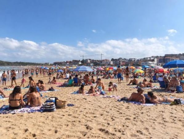 A crowded beach with people sunbathing and walking. - Eagle Eyes 1 (Puente Avíos)