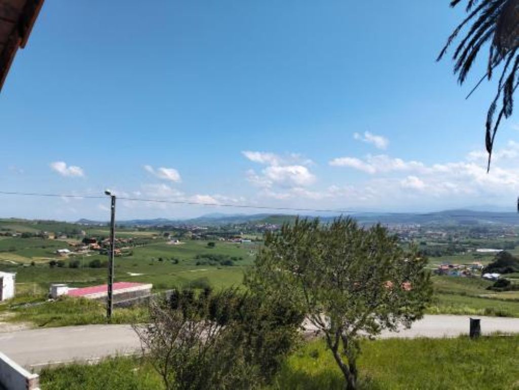 Ländliche Landschaft mit blauem Himmel, einer Straße und einem entfernten Blick auf eine Stadt.