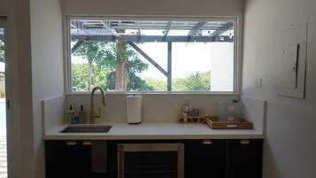 Una cocina con ventana, lavamanos y armarios.