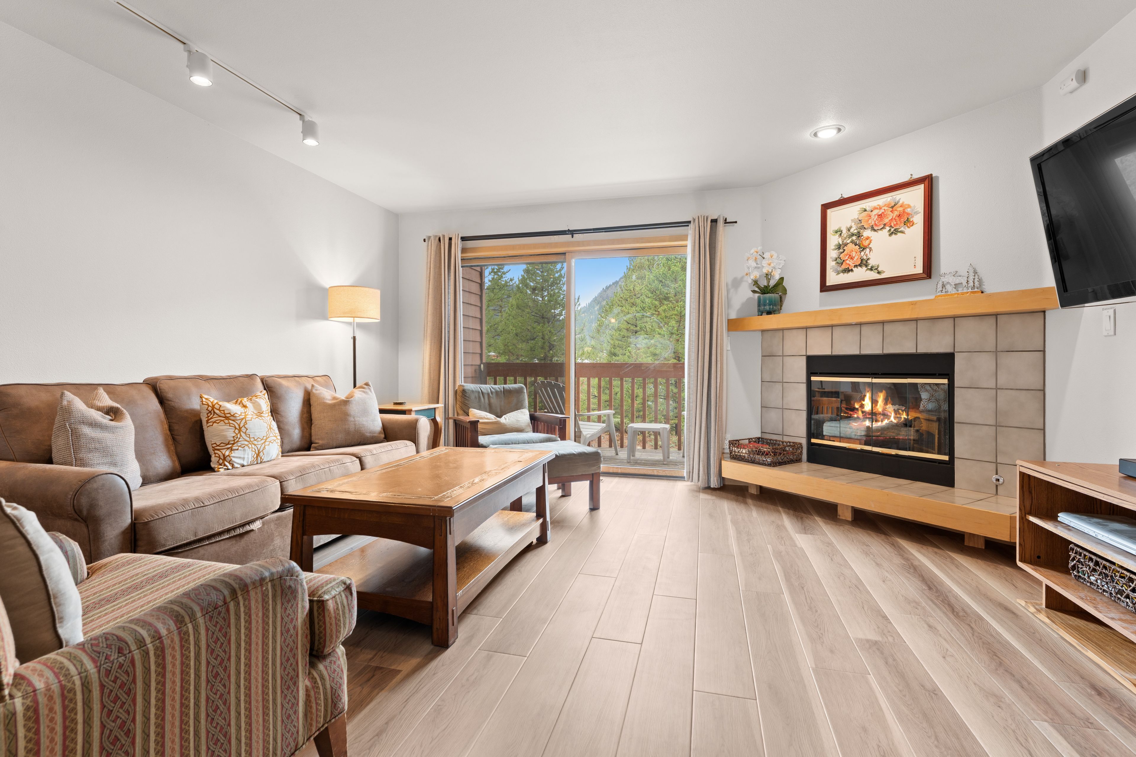 A modern living room with a sofa, coffee table, and fireplace.