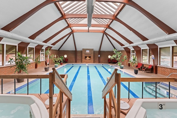 An indoor swimming pool with a high ceiling and skylights, surrounded by brick walls and potted plants. - Frisco Mountain Getaway with Pool & Hot Tub (Frisco)