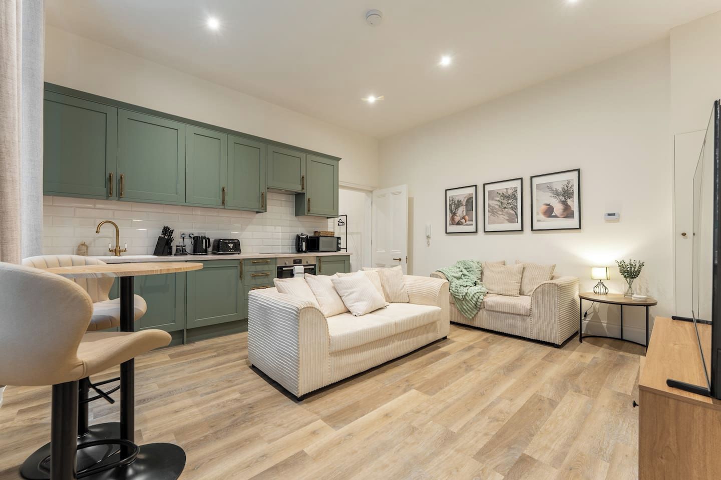 A modern living room with a sofa and a dining area with a table and chairs.