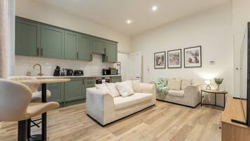 A modern living room with a sofa and a dining area with a table and chairs.