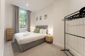 A neatly arranged bedroom with a bed, bedside table, and a wardrobe. - The Annexe | Private Garden & Westbourne Location (Bournemouth)