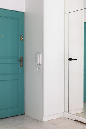 A teal door with a brass handle and a white door with a black handle. - Nowoczesne Studio w Kamienicy (Poznań)