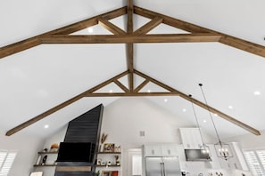 A spacious kitchen with high ceilings and exposed wooden beams.
