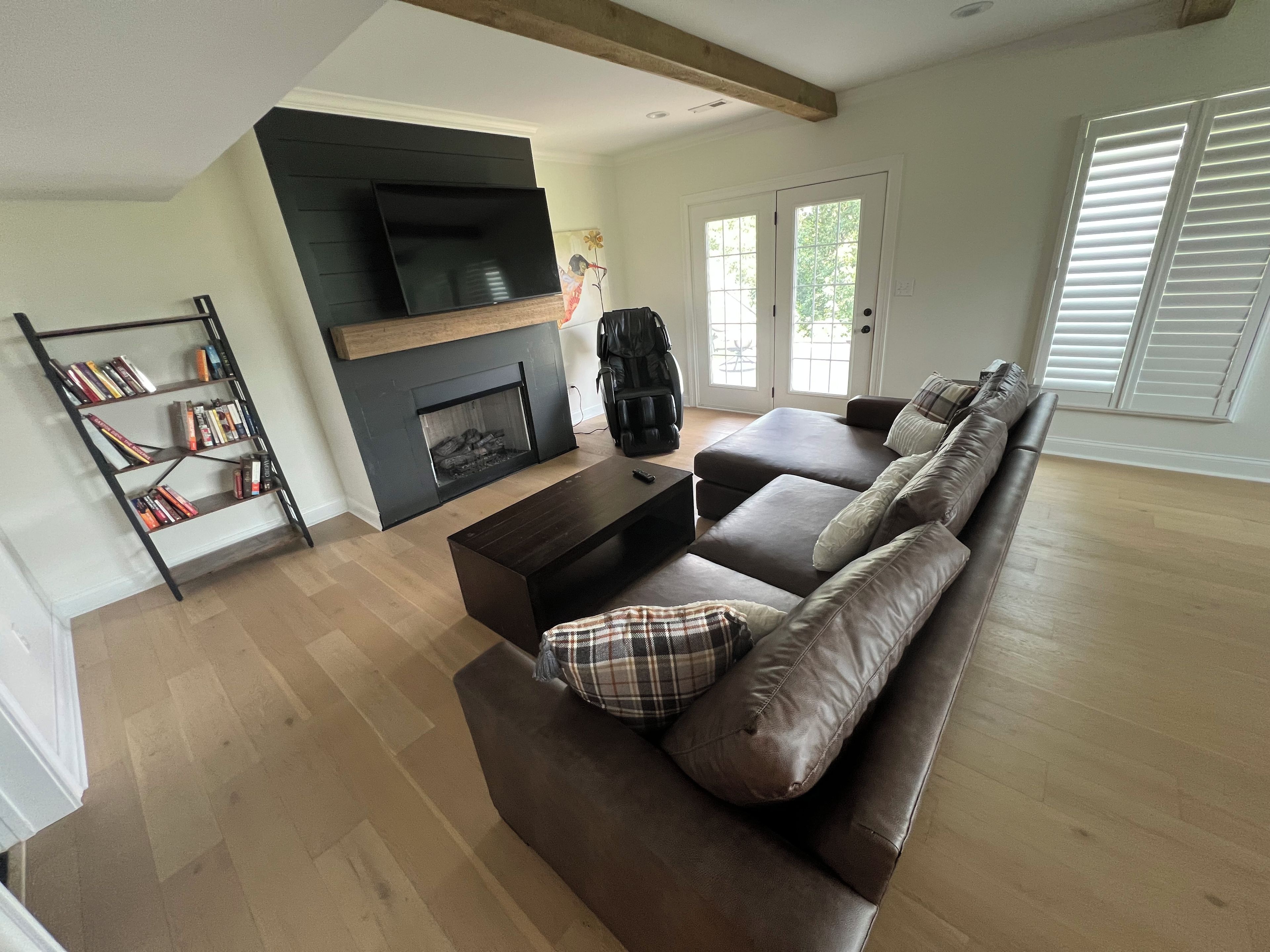 A living room with a fireplace, a sofa, a coffee table, and a bookshelf.