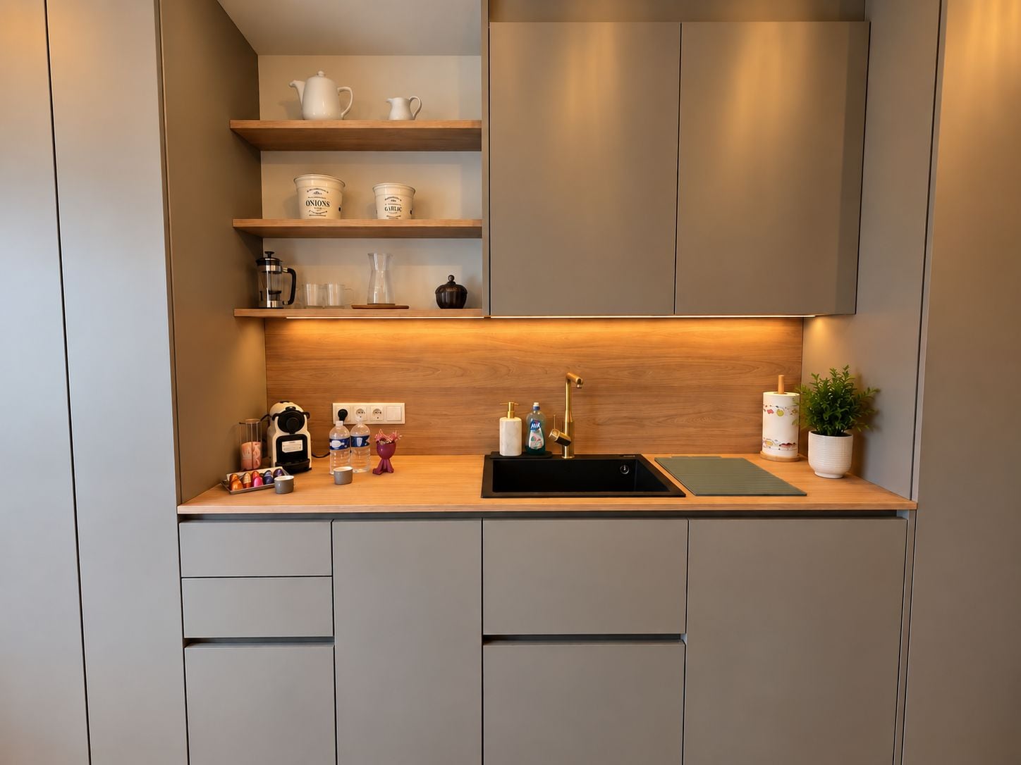 Una cocina moderna con un lavamanos integrado, encimera de madera y armarios de almacenamiento.