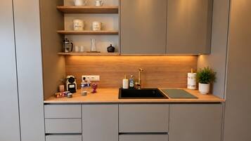 Una cocina moderna con un lavamanos integrado, encimera de madera y armarios de almacenamiento.