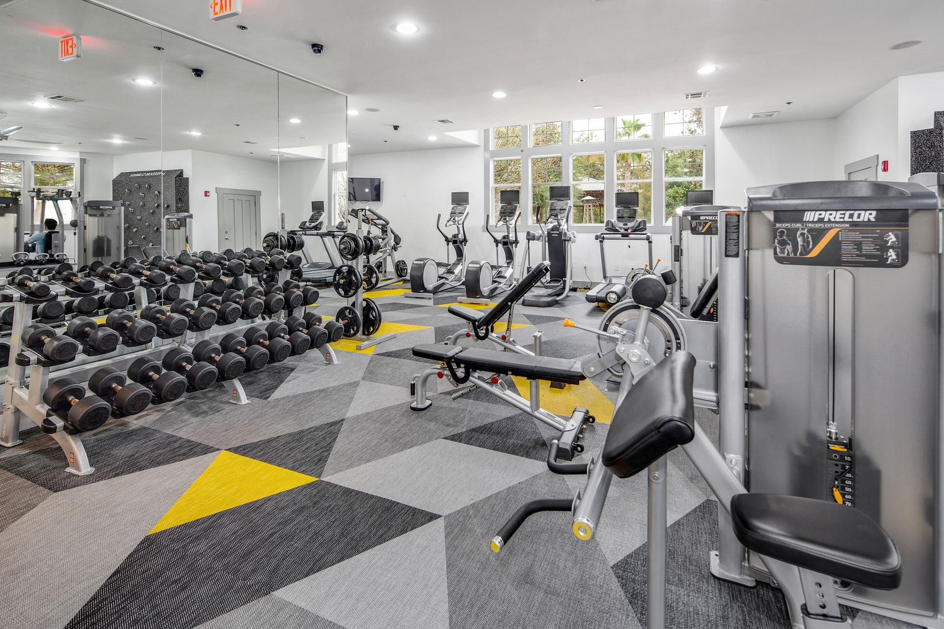 A gym with various exercise equipment, including dumbbells, treadmills, and weight machines.