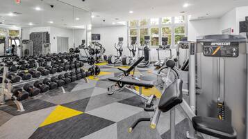 A gym with various exercise equipment, including dumbbells, treadmills, and weight machines.