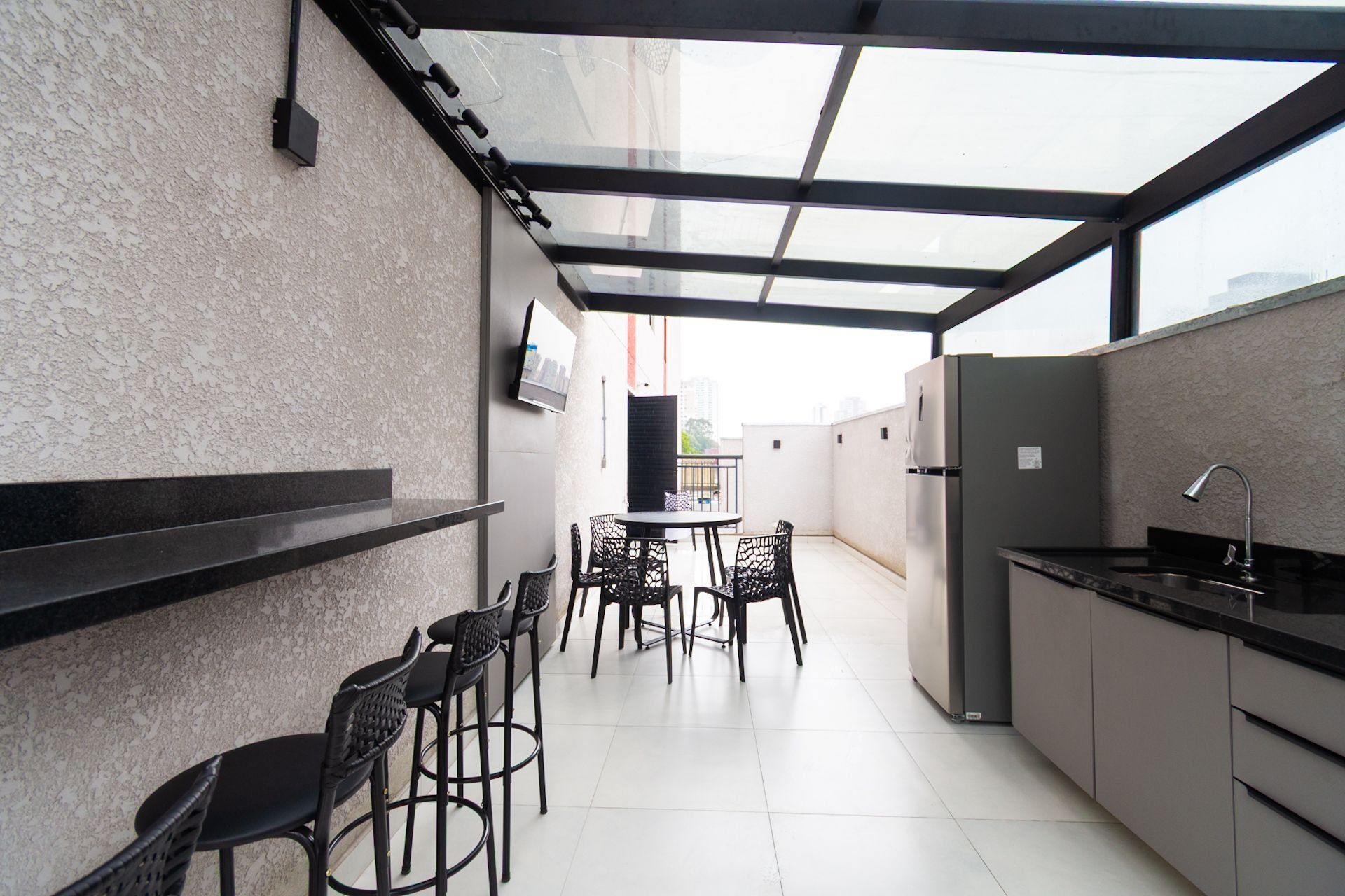 A compact kitchen with a dining area, a built-in refrigerator, and a glass-enclosed patio.