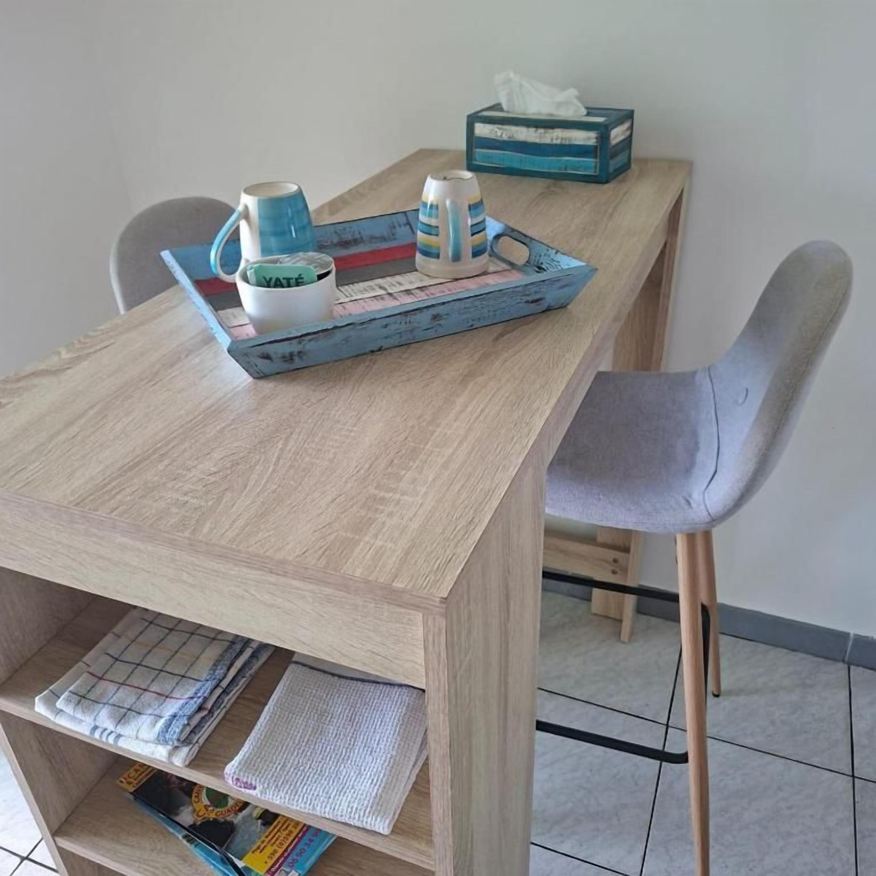 A wooden table with a tray holding a mug, a cup, and a tissue box.