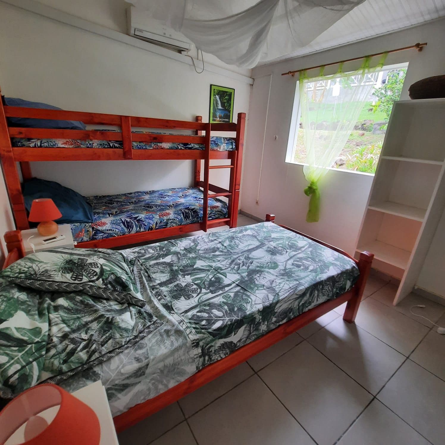 Habitación con literas, una ventana, estante y lámpara.