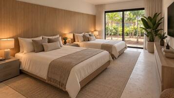 A modern bedroom with two beds, a ceiling fan, and a view of a tropical garden.