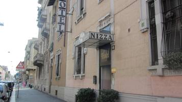 Un edificio con un letrero que dice 'HOTEL' y otro que dice 'NIZZA', indicando un hotel y una pizzería.