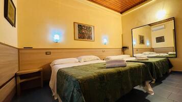 Habitación de hotel con dos camas, techo de madera y un espejo grande en una pared.