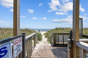 A wooden boardwalk leading to a beach with a no smoking and no vaping sign. - Direct Oceanfront Balcony with Pools (North Myrtle Beach)