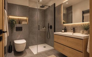 A modern bathroom with a glass-enclosed shower, a white toilet, and a wooden vanity with a mirror. - 10m from ski slopes, 4th floor, view ski slopes, fitness, sauna, terrace, balcony, tv, ski locker (Mont-de-Lans)