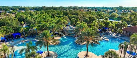 Un resort con una amplia piscina central, rodeado de palmeras y zonas de descanso.