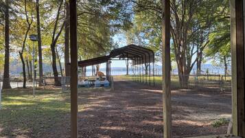 A covered picnic area with a view of a lake and trees.