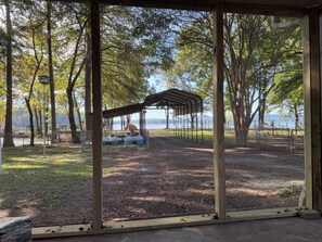 A covered picnic area with a view of a lake and trees.