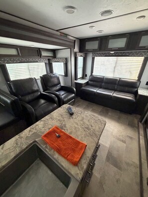 Ein kompaktes Wohnmobil-Interieur mit einer Sitzecke, einem kleinen Tisch und einer Küchenzeile.