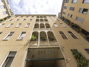Ein mehrstöckiges Gebäude mit Balkonen, Fenstern und einem Innenhof.