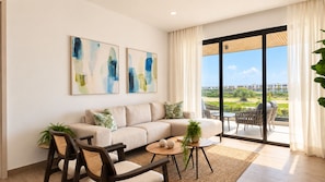 A modern living room with a sofa, chairs, a coffee table, and artwork on the wall.