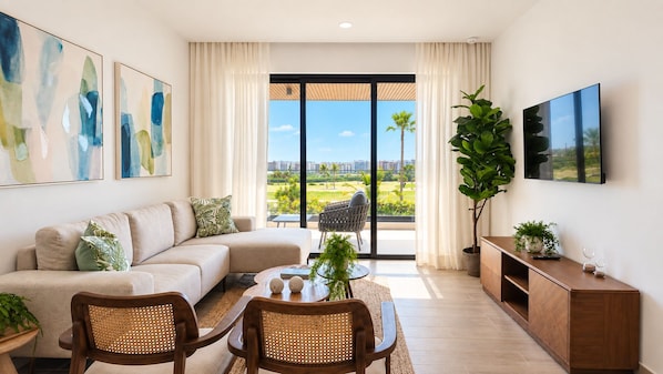 A modern living room with a sofa, chairs, a coffee table, and a TV. There is a large window with a view of a cityscape and palm trees.