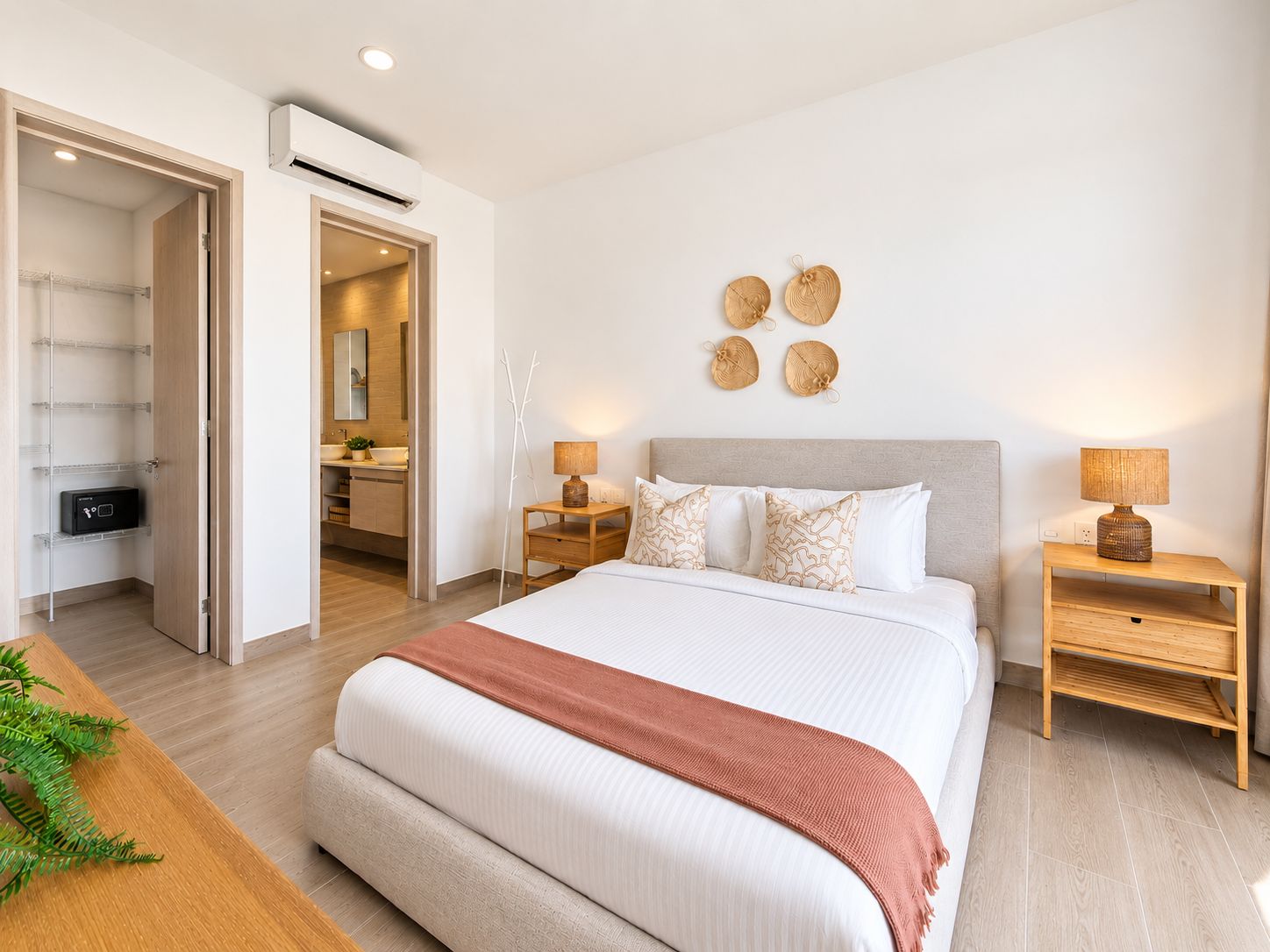 A modern bedroom with a large bed, bedside tables, a wardrobe, and a bathroom visible through an open door.