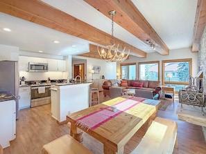 A spacious kitchen with a central island, wooden beams, and a chandelier. - New Listing! Updated Plaza — Walk-to-Lift 3 bedroom Condo with Covered Garage (Crested Butte)