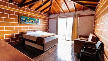 Una camera da letto con un letto, una sedia e un quadro appeso al muro.