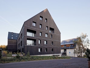 A modern multi-story building with a dark facade and multiple windows. - Apartment Lagom by Interhome (Abertamy)