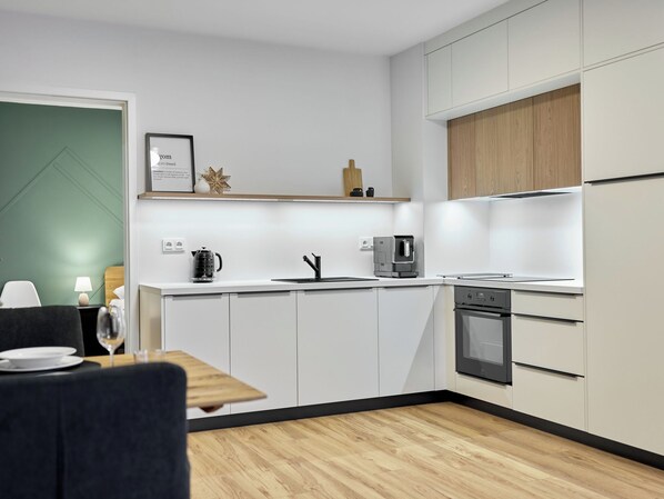 A modern kitchen with white cabinetry, a built-in oven, and a coffee maker. - Apartment Lagom by Interhome (Abertamy)