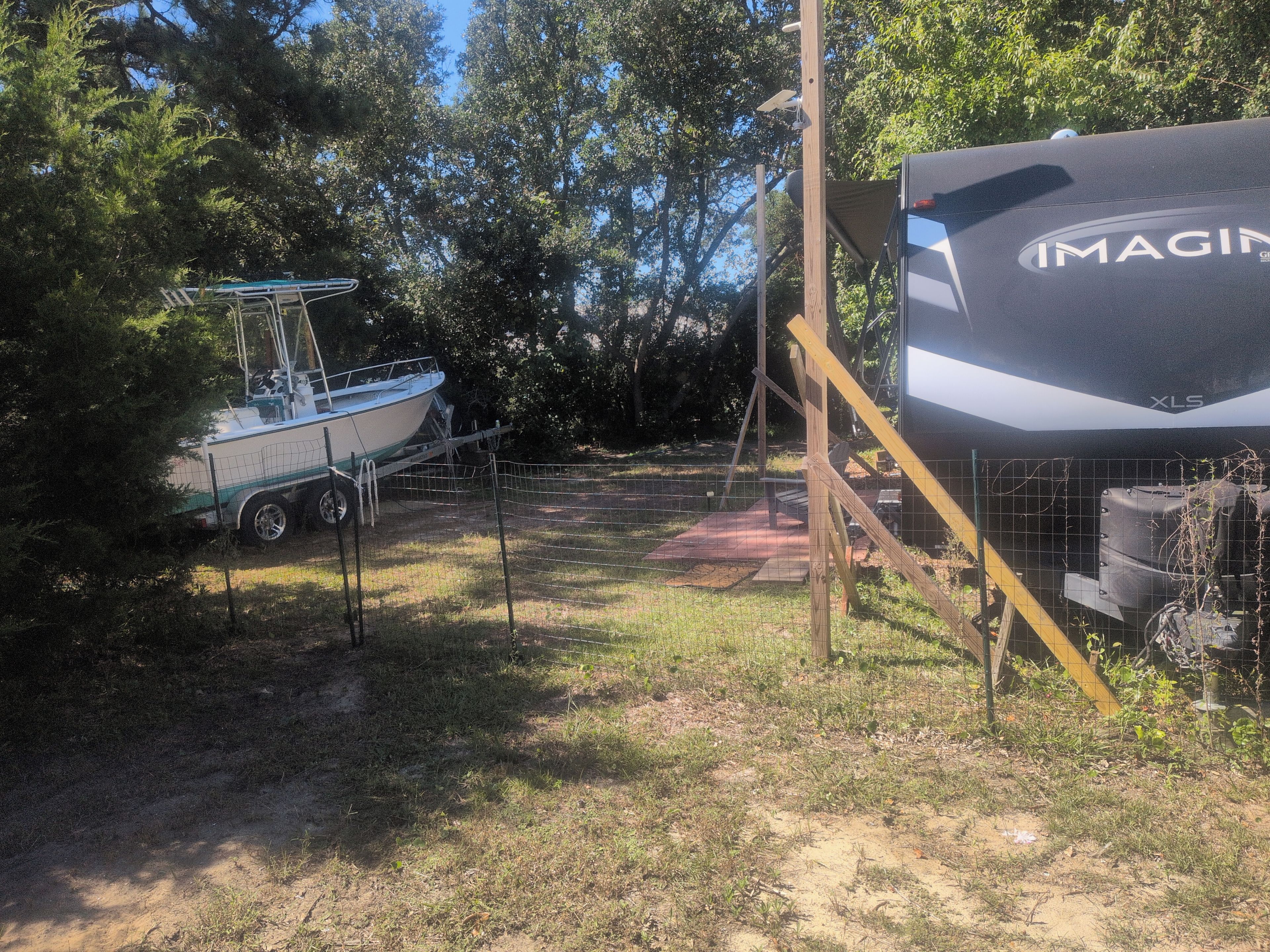 A boat on a trailer and a large RV with the brand name 'IMAGIN' visible.