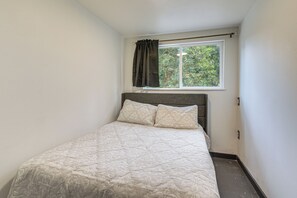 A single bed with a headboard, a window with curtains, and a view of greenery outside. - 4-Acre Angleton Retreat w/ Outdoor Seating (Angleton)