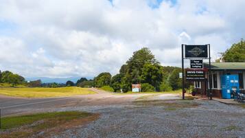 A roadside sign for Sahara Club, indicating food, live music, lodging, and drive-thru services.