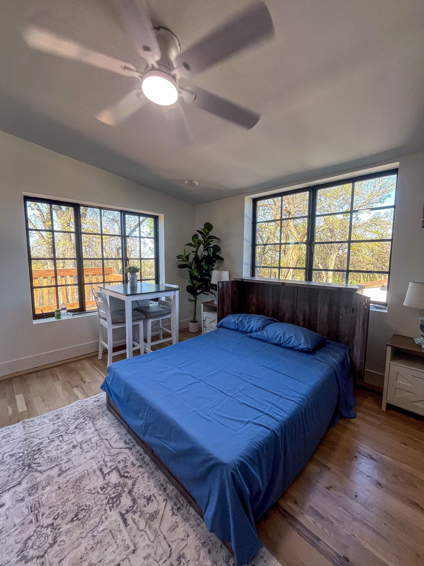 Une chambre à coucher avec un lit, un bureau et deux fenêtres.