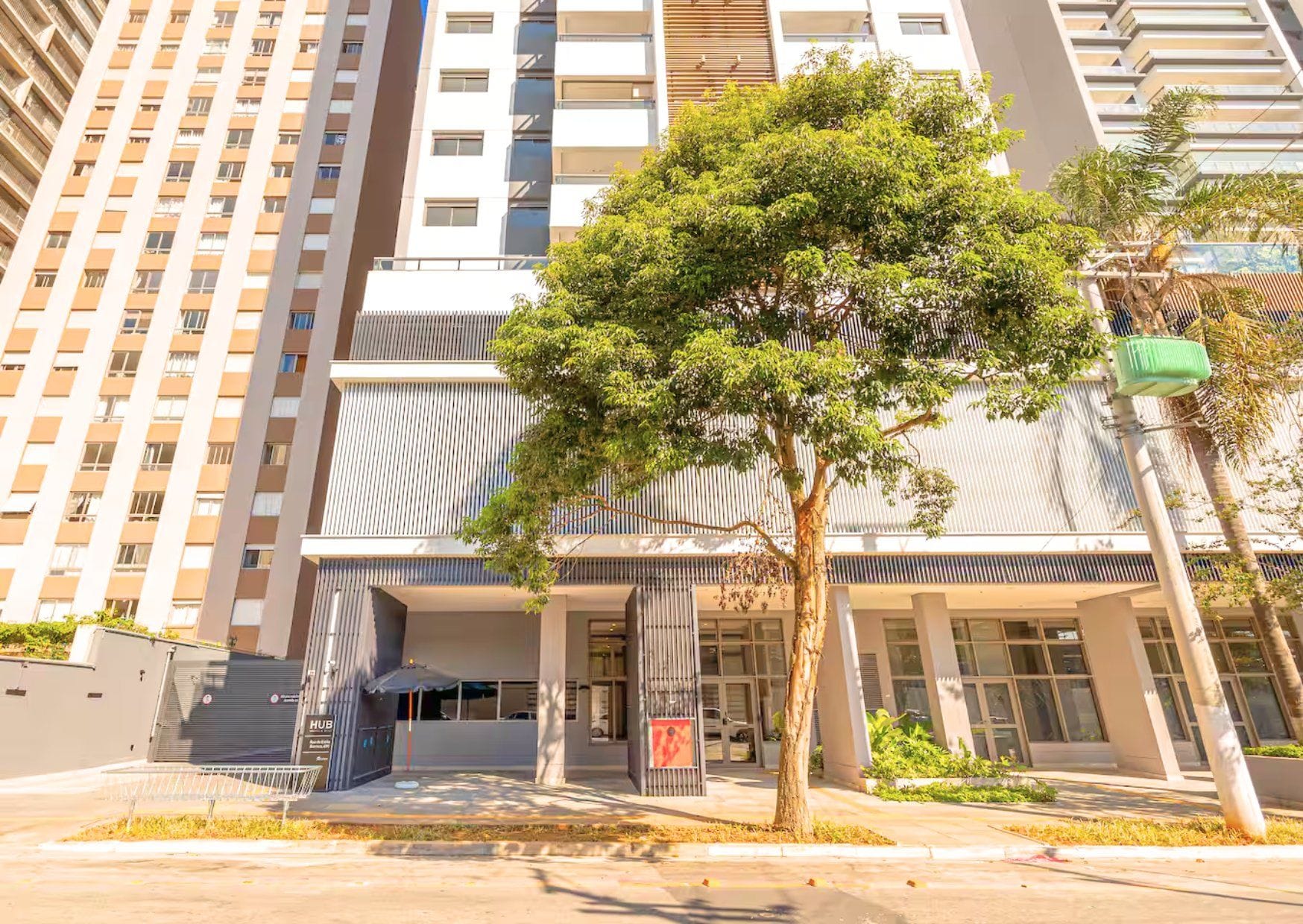 A modern building with a tree in front, a gated entrance, and a sign that reads 'HUB'.