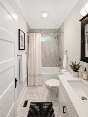 A modern bathroom with a bathtub, toilet, and sink. - Annie A’s- Downtown Port St. Joe Cottage: Pet Friendly + Boat Parking (Port St. Joe)