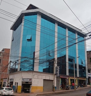 A multi-story commercial building with a reflective glass facade and a flat roof. - Hotel Inka Palace Huayna Ccapac Cusco (Cusco)