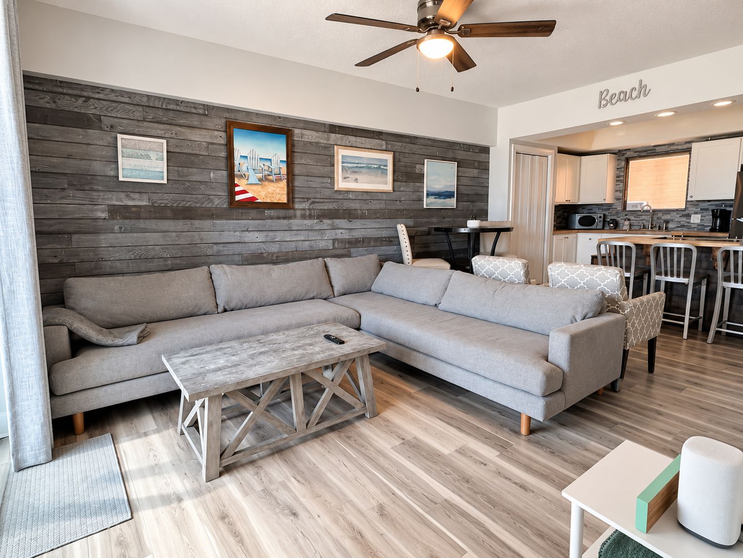 A modern living room with a sectional sofa, a coffee table, and a ceiling fan.