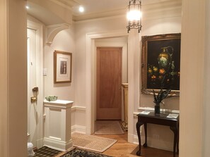 A hallway with a wooden door, a framed picture on the wall, a glass display case, and a patterned rug. - 2-bedroom apartment in marvelous Chicago lakefront with  AC (Chicago)