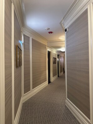 A hallway with patterned walls, a patterned carpet, and a ceiling with recessed lighting and a smoke detector. - 2-bedroom apartment in marvelous Chicago lakefront with  AC (Chicago)