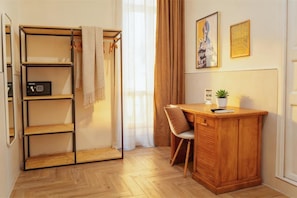 A room with a desk, chair, and a shelving unit with a towel. - Palazzo Bevilacqua Rooms (Naples)