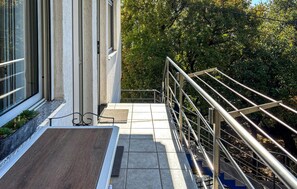 Eine Treppe mit Metallgeländern führt zu einem Hauseingang.
