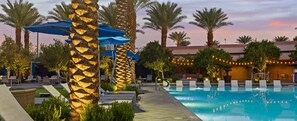 A poolside area with lounge chairs, umbrellas, and palm trees. - Margaritaville - Desert Blue Oasis Resort is Minutes from the Las Vegas Strip NV (Las Vegas)